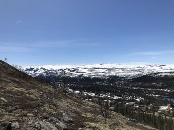 Scenic view of snowcapped mountains against blue sky