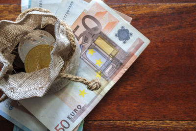 High angle view of coins and paper currency on table