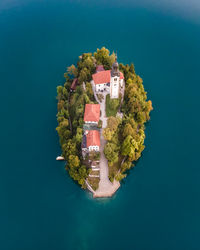 High angle view of house by sea against clear blue sky