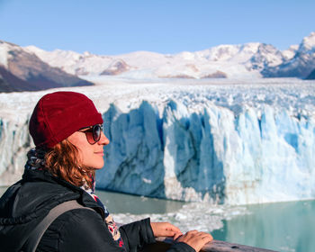 Woman standing on snowcapped mountains during winter in glacier perito moreno