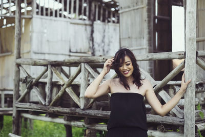 Portrait of young woman standing against built structure