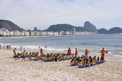 People at beach against sky