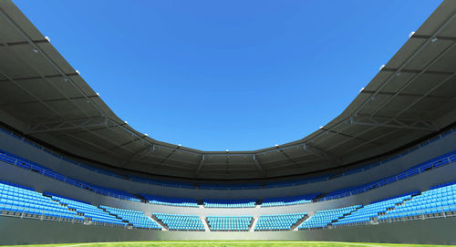 Low angle view of building sport stadium blue sky