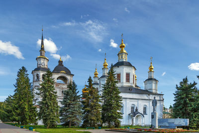 Low angle view of trees and building against sky