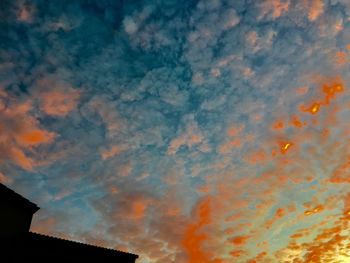 Low angle view of silhouette roof against sky