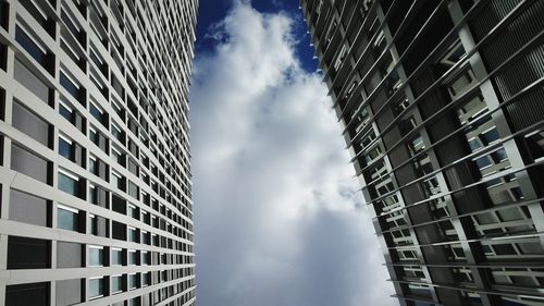 Low angle view of modern building against cloudy sky