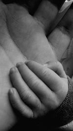 Close-up of father holding baby hand