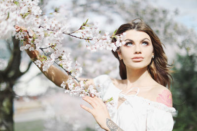 Portrait of a beautiful young woman with cherry blossom