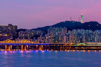 Illuminated city at waterfront at night