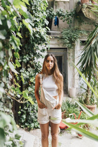 Young woman standing with hands in pockets