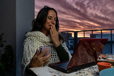 Young woman using laptop while sitting on table