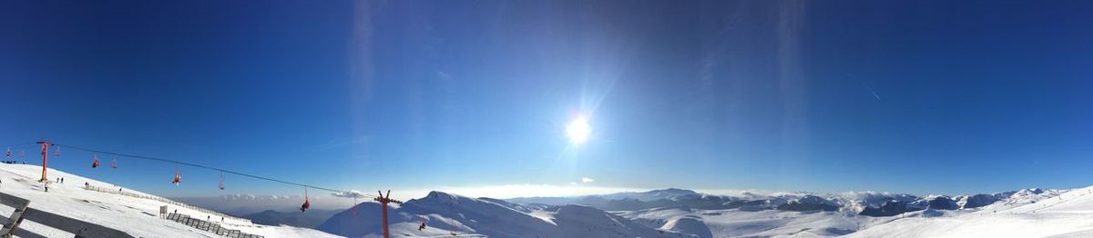 Low angle view of snowcapped mountain against blue sky