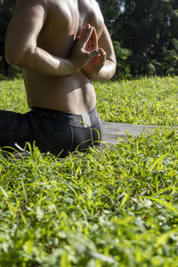 Latin american man doing yoga posture, yoga posture, bee backwards prsthatah brahmara, forest