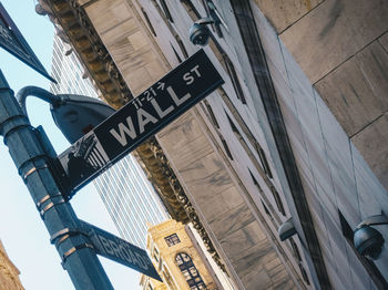 Low angle view of road sign against built structures