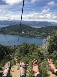 Low section of female friends on ski lift against sea