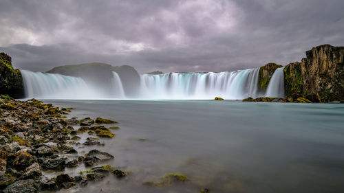 Scenic view of waterfall against sky