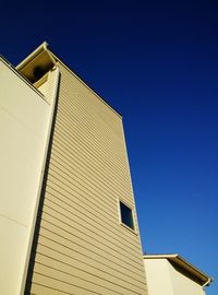 Low angle view of buildings against clear blue sky