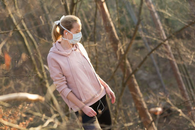 Woman wearing mask standing at park