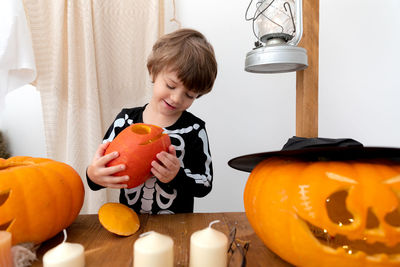 Side view of boy holding pumpkin