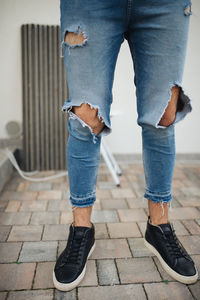 Low section of man standing on sidewalk