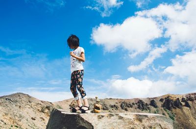 Low angle view of man standing against blue sky