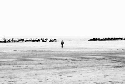 Silhouette man on beach against clear sky