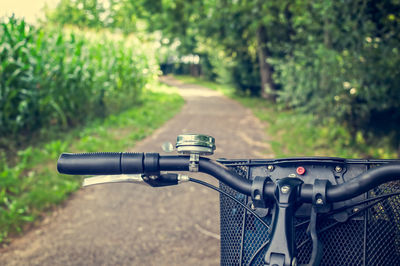 Close-up of bicycle on road amidst plants