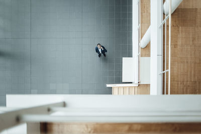 Senior businessman looking up in office corridor