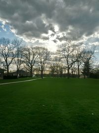 Scenic view of grassy field against cloudy sky