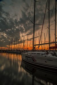 Boats in sea at sunset