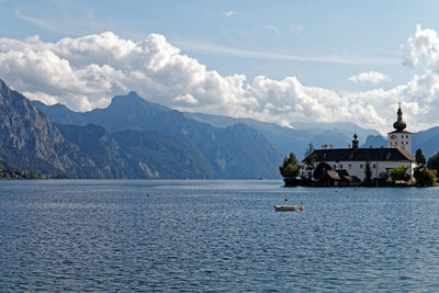 Scenic view of sea by mountains against sky