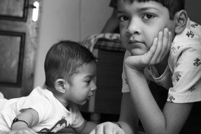 Portrait of boy with brother lying at home