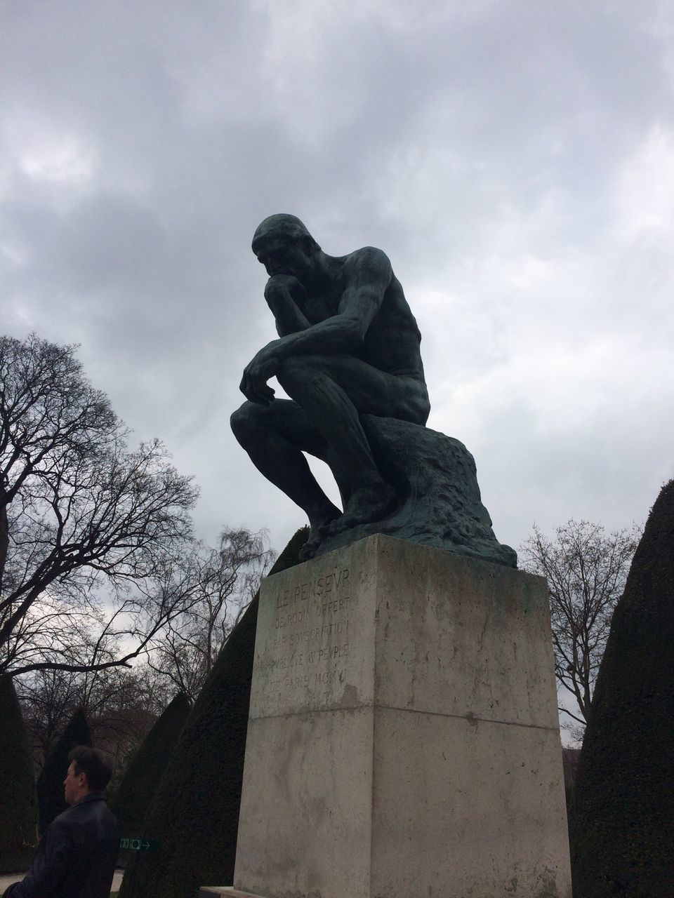 sky, low angle view, lifestyles, men, cloud - sky, statue, leisure activity, human representation, sculpture, cloudy, cloud, holding, art, full length, art and craft, standing, silhouette