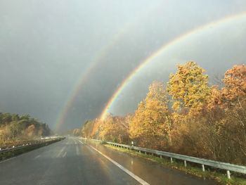 Rainbow over wet road during rainy season