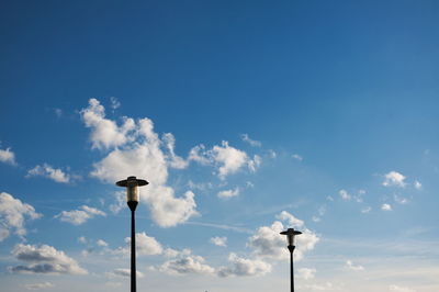 Low angle view of street light against blue sky