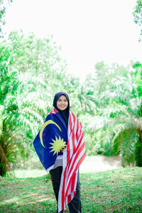 Muslim woman happy holding a malaysian flag. malaysia independence day.