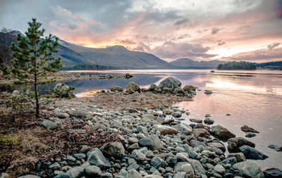 Surface level of pebble beach against scenic sky