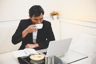 Man drinking coffee cup on table