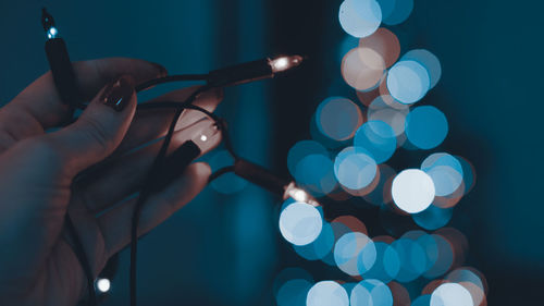 Close-up of hand holding illuminated lighting equipment