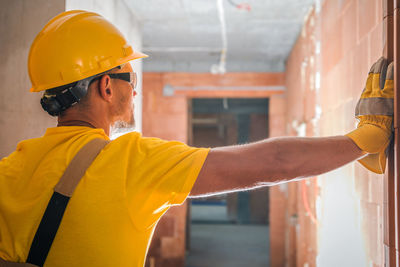 Rear view of worker standing at construction site