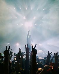 Crowd at music concert against sky at night