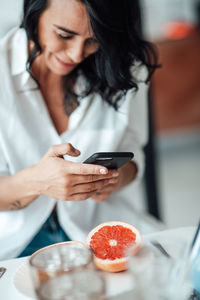 Midsection of woman using mobile phone