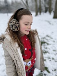 Smiling girl looking down during winter