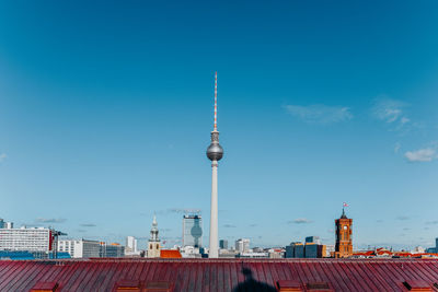 View of skyline of berlin with tv tower against blue sky