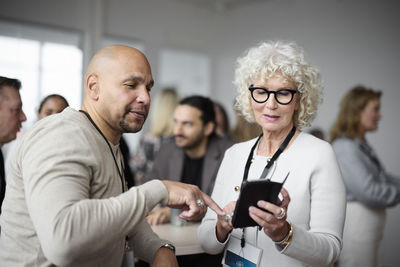 Business people using cell phone during coffee break