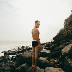 Full length of man standing on beach against clear sky