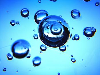 Close-up of bubbles against blue water