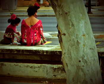 Rear view of women sitting outside temple