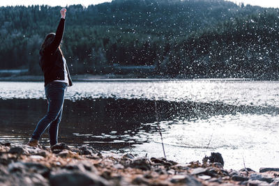 Side view of woman standing at lakeshore