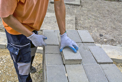 Low section of man holding brick